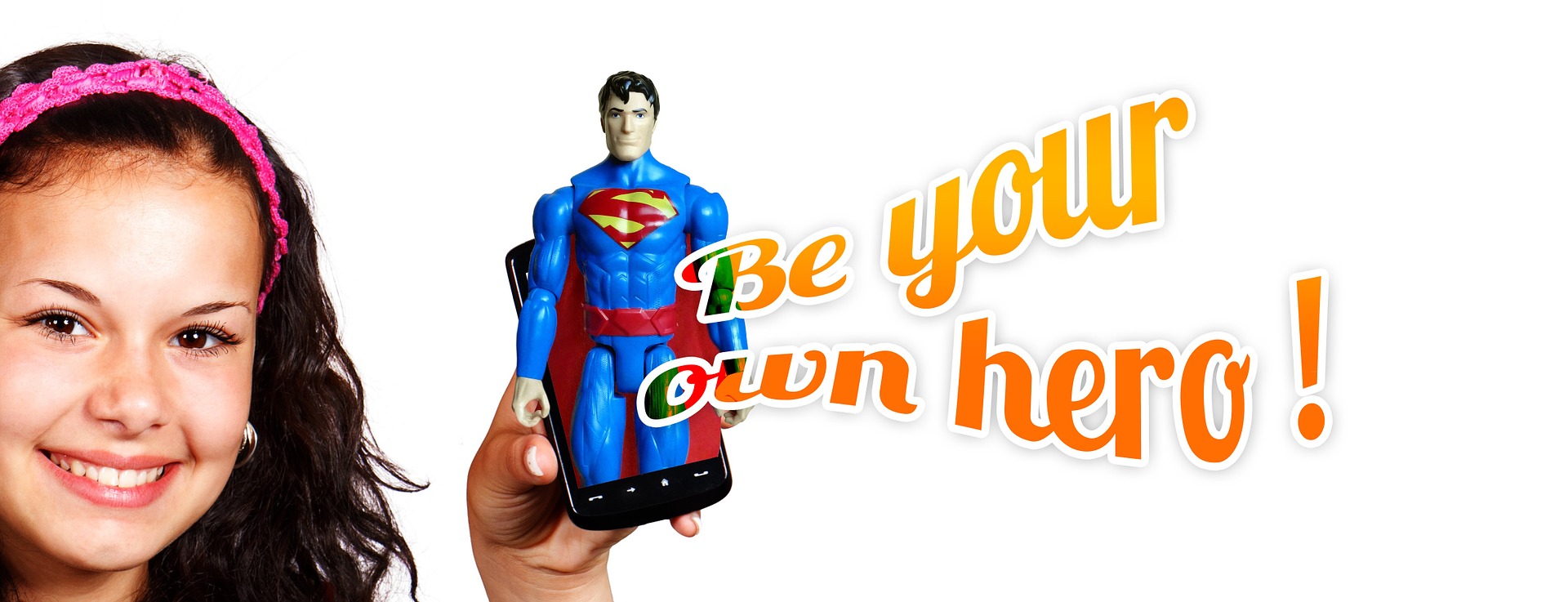 A young woman's face smiles at us as she holds up a mobile phone. From the phone emerges a Superman image and the words "Be your own hero!"