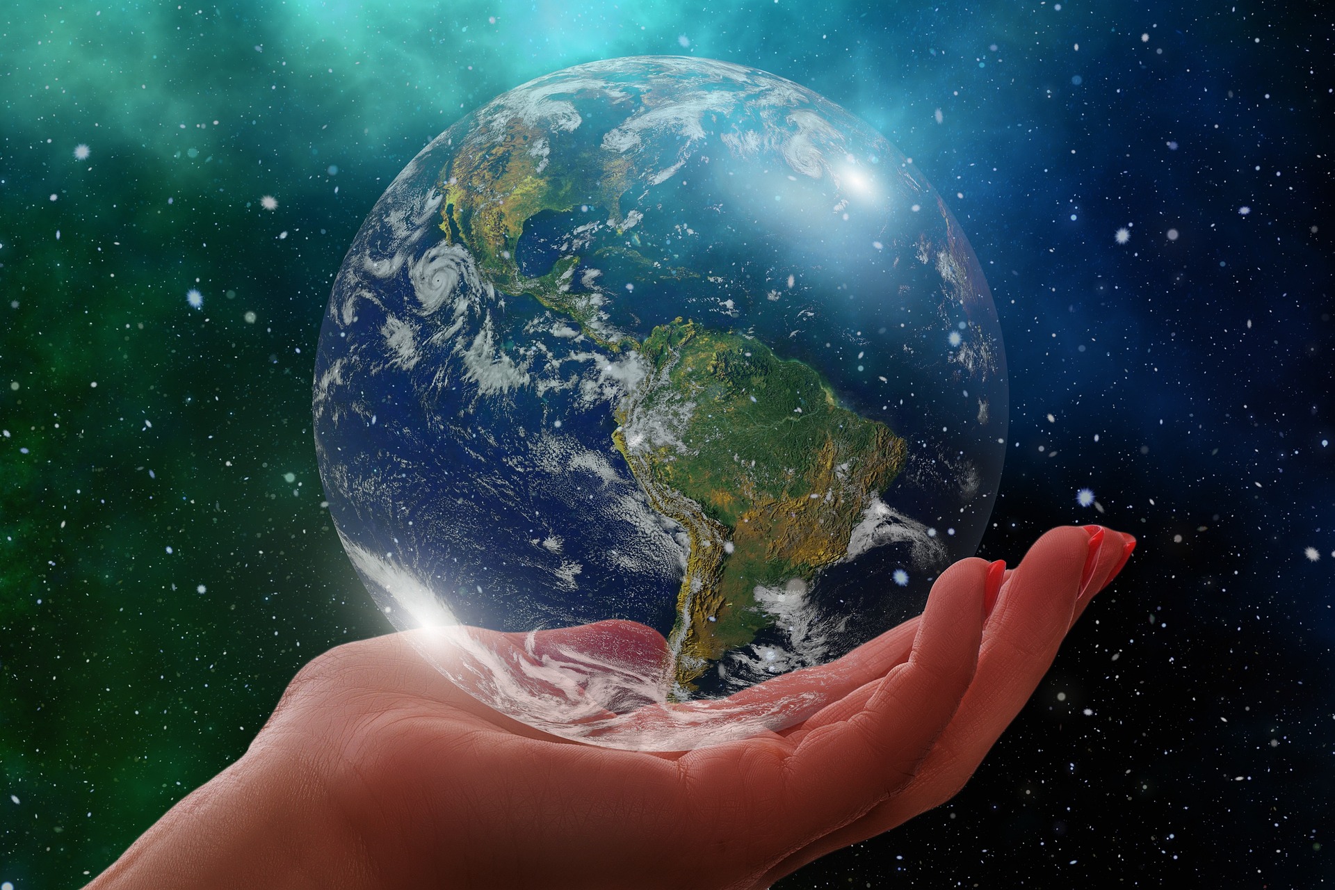 A hand cups a translucent planet Earth in space