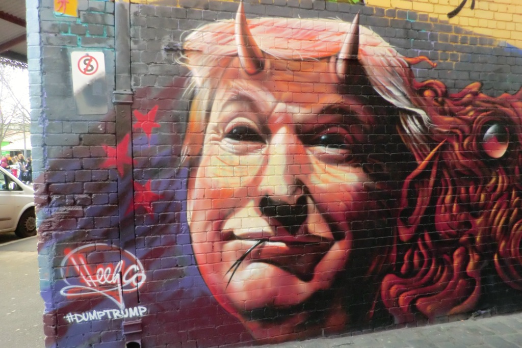 Graffiti of Trump as a devil with horns on brick wall in Australia