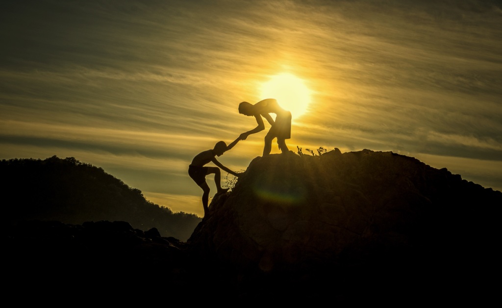 Young men support at mountain top
