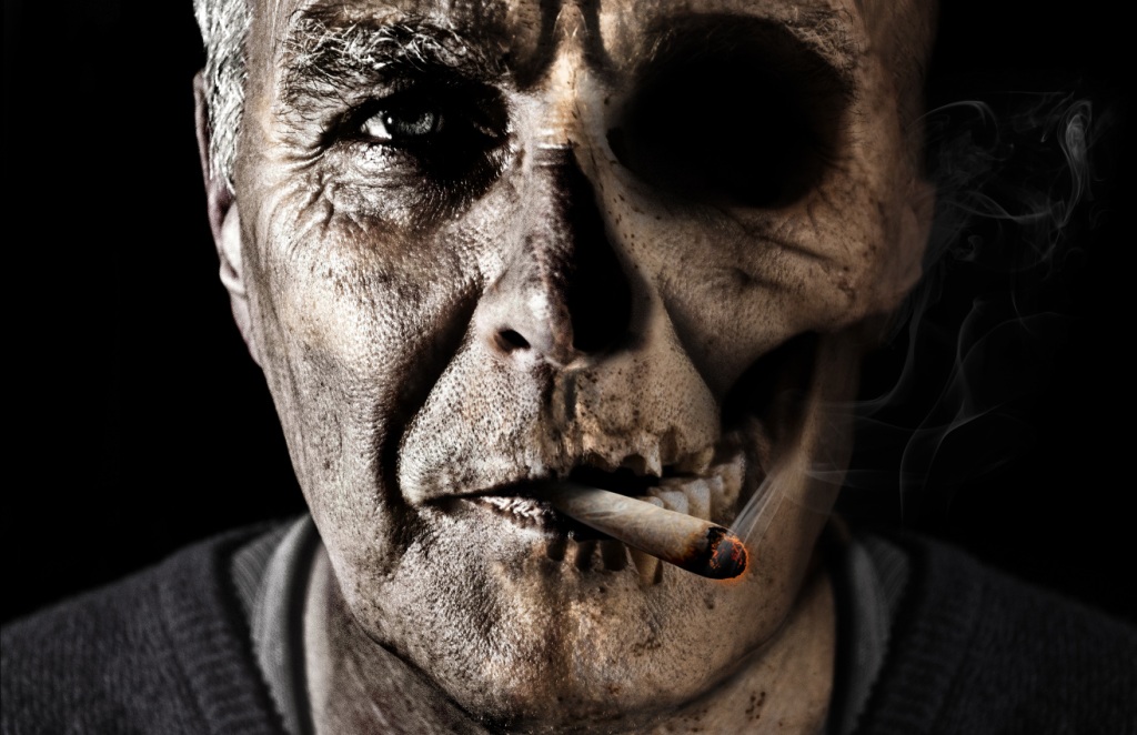 Face of older man addicted to smoking, one side flesh, the other side skull
