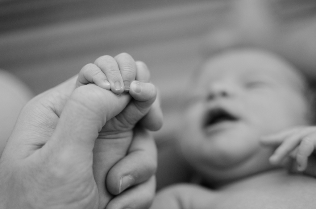 Baby grips adult thumb