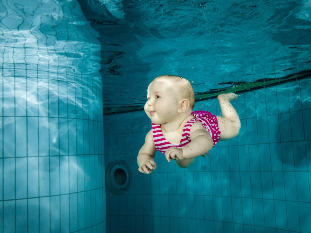 Baby happily swims underwater