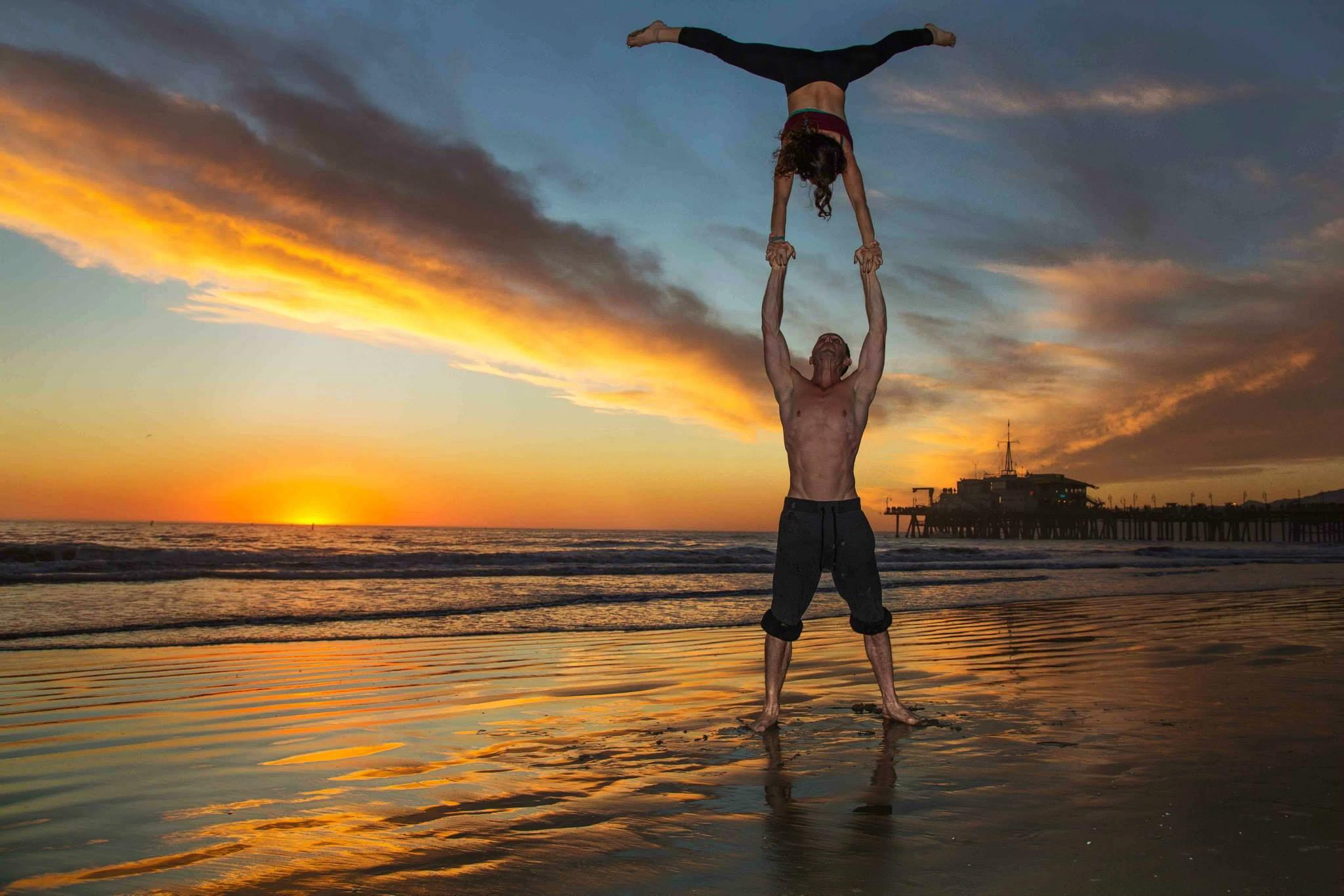 Couple doing acrobatic yoga on beach