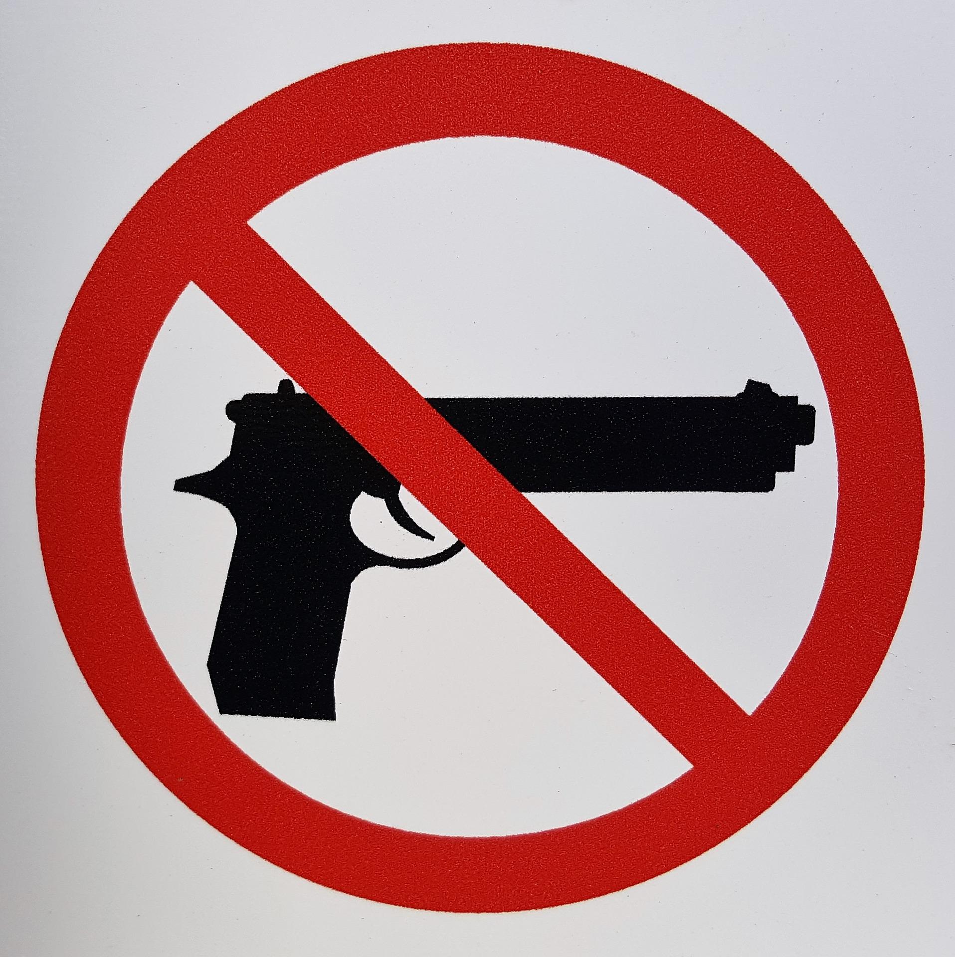 A gun control sign. A handgun is enclosed by a red circle and a diagonal red stripe that crosses over the handgun.
