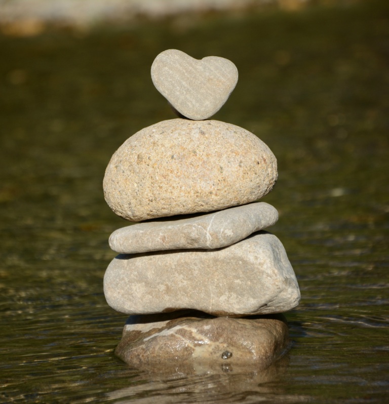 Stones stacked in water, heart stone atop