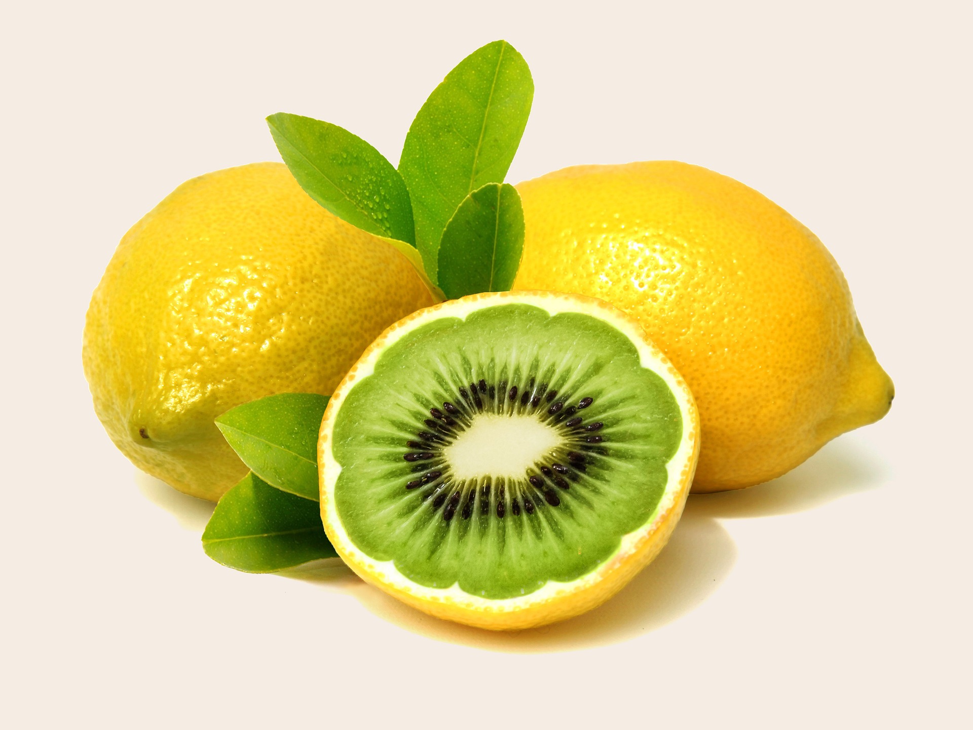 Three lemons, on cut in half revealing a kiwi fruit interior