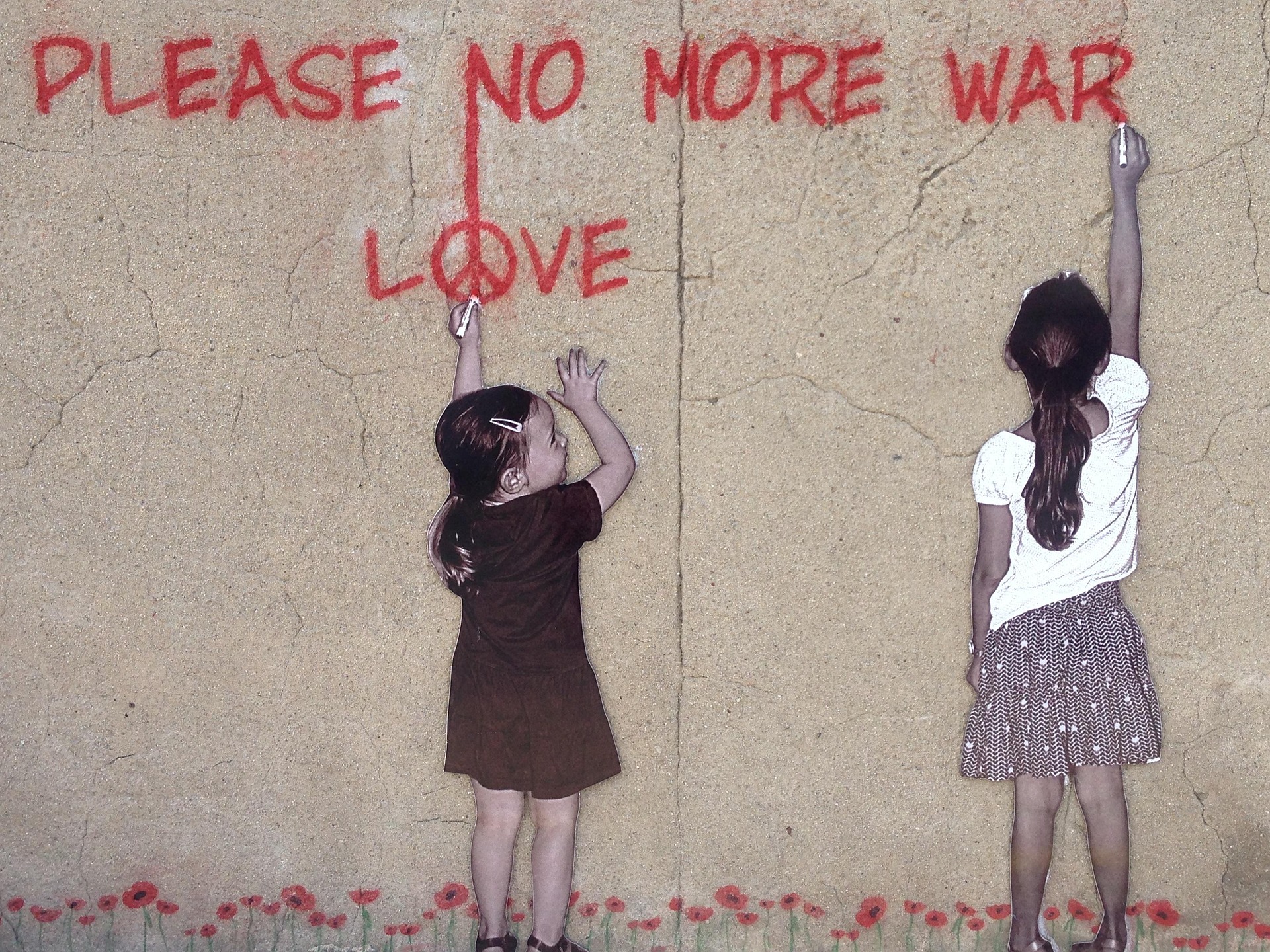 Two young kids are drawing graffiti on a wall. In red, it reads: 'Please no more war. Love.' There are small flowers at the base of the wall.