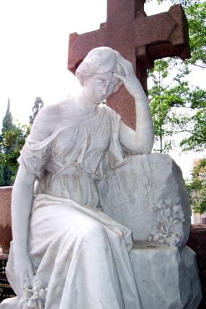 Statue of mourning woman by grave