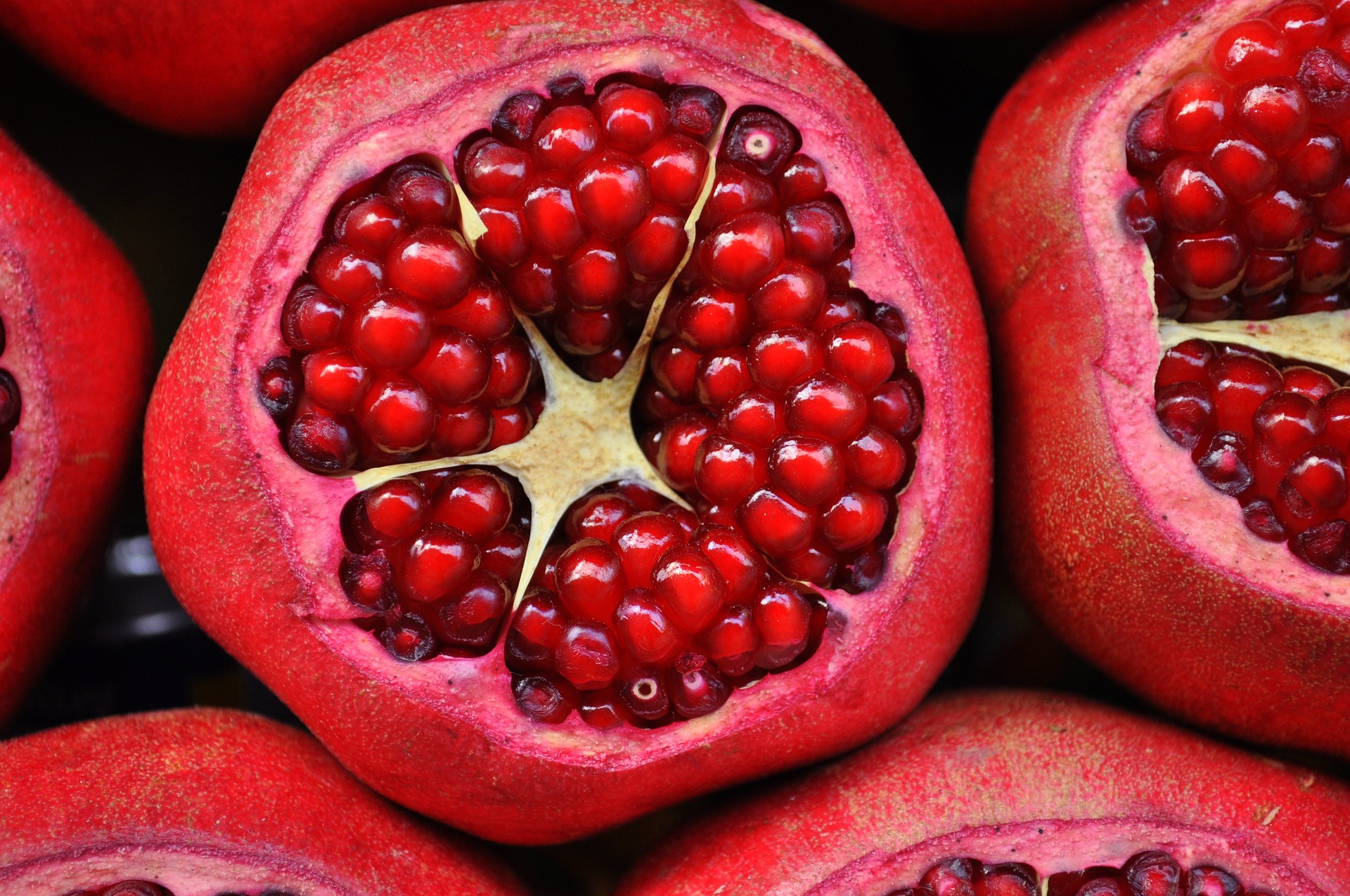 A sliced-open, bright pink/red pomegranate. It looks like a mandala of Love.