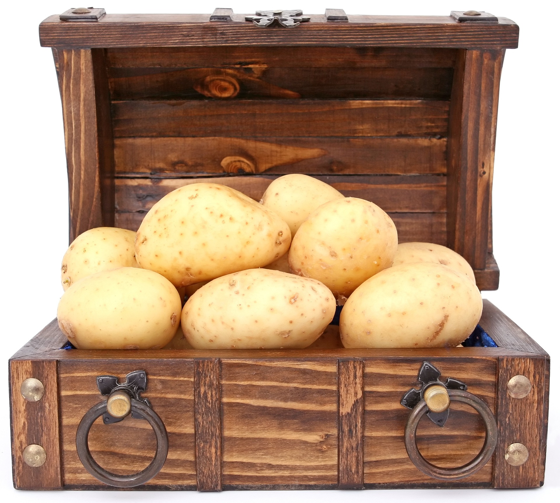 Wooden treasure chest filled with large potatoes