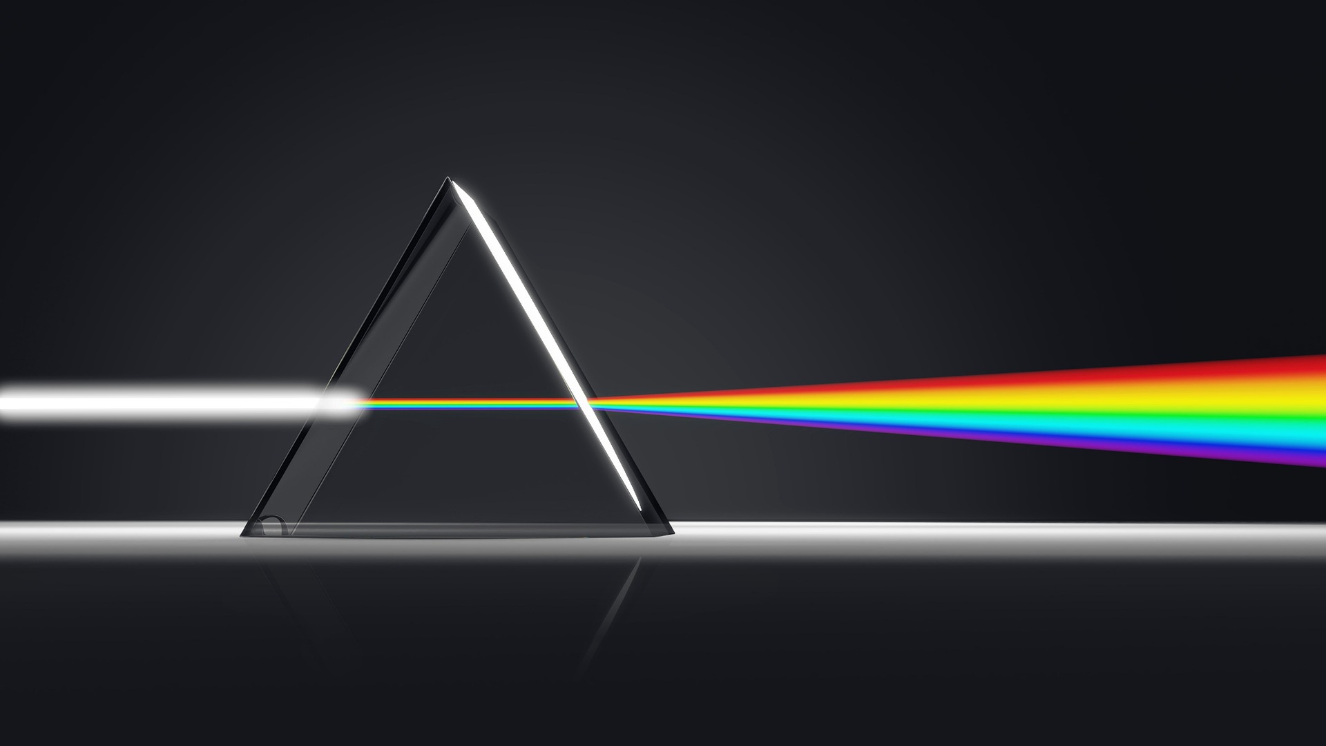 On a black background, a prism splits white light into a rainbow of colours