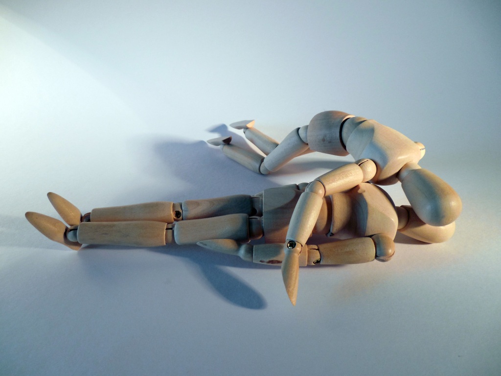 Two jointed wooden human figures, the one giving the other emergency resuscitation