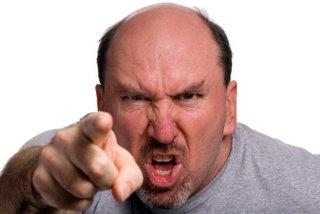 An angry balding man pointing his finger directly at us