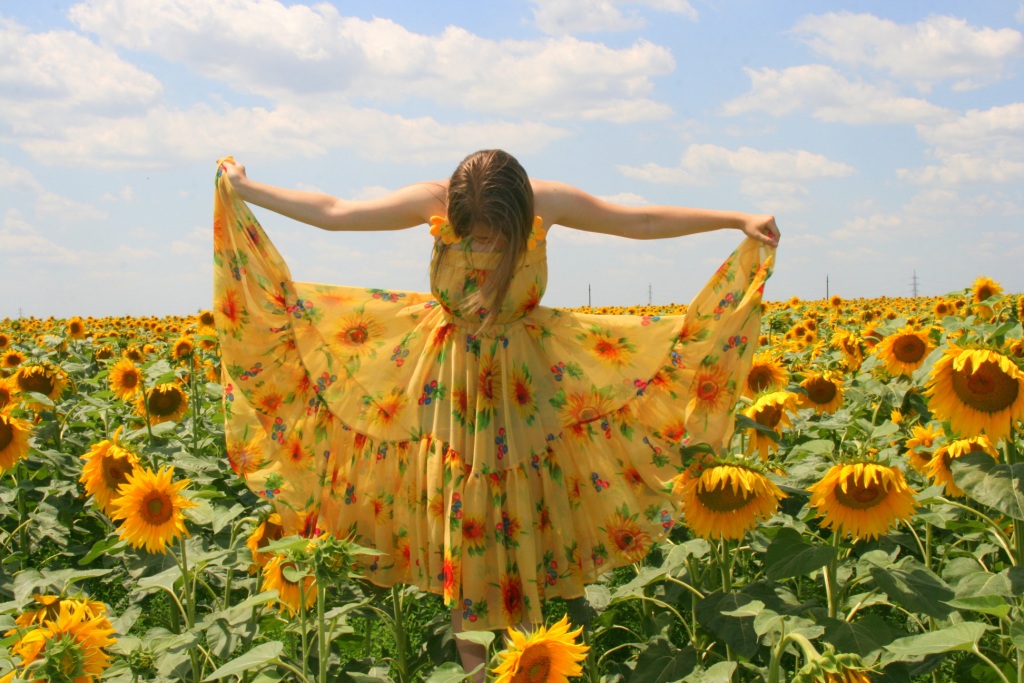 Woman with sunflower dress in sunflower field