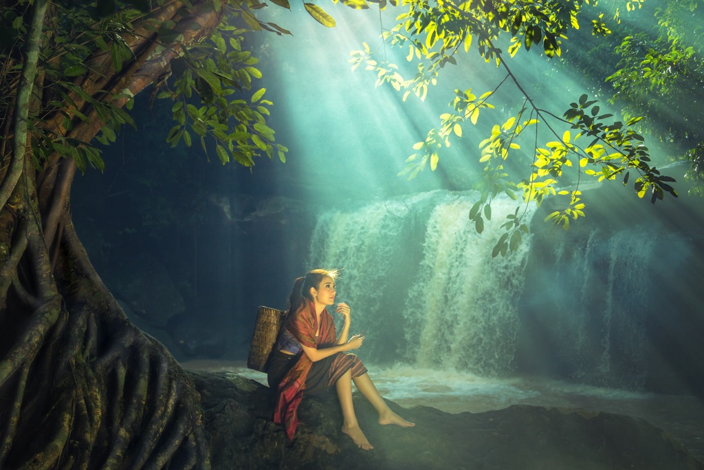 Happy woman by waterfall