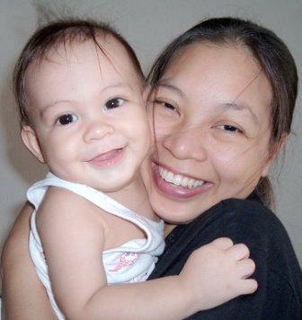 Happy Family - Mother and baby daughter (held close to mother's face) smiling with joy