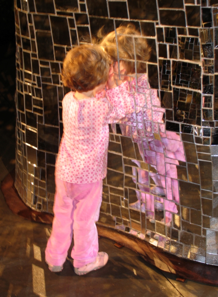 Girl stares into cracked mirror