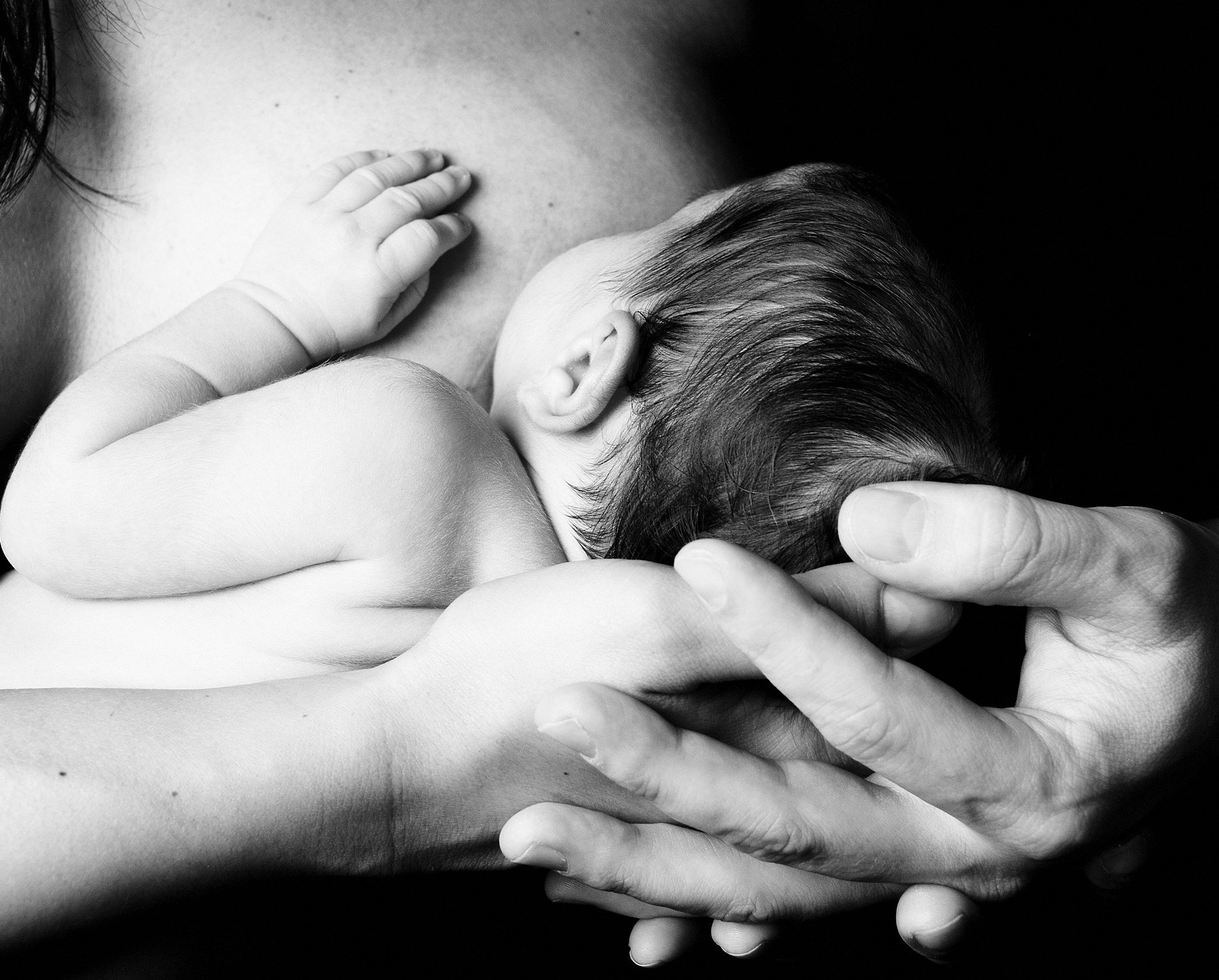 Black-and-white photo of a breastfeeding mother with her newborn