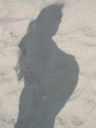 Silhouette on sand of a pregnant woman