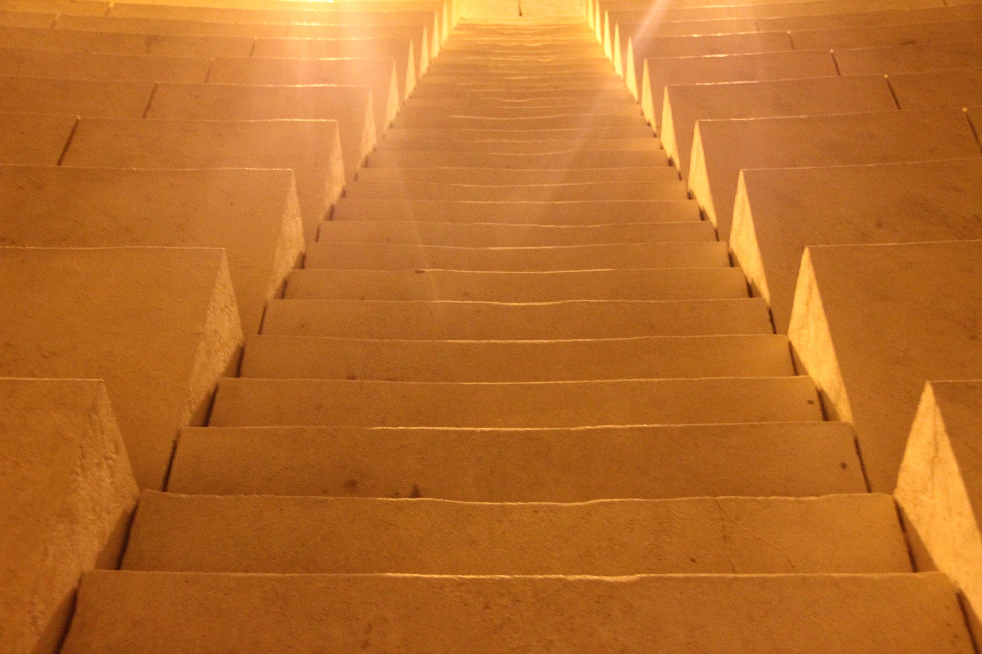 We are looking up a stairs made from giant stone blocks, like the pyramids. Light glows from the stones and especially from the top of the stairs.