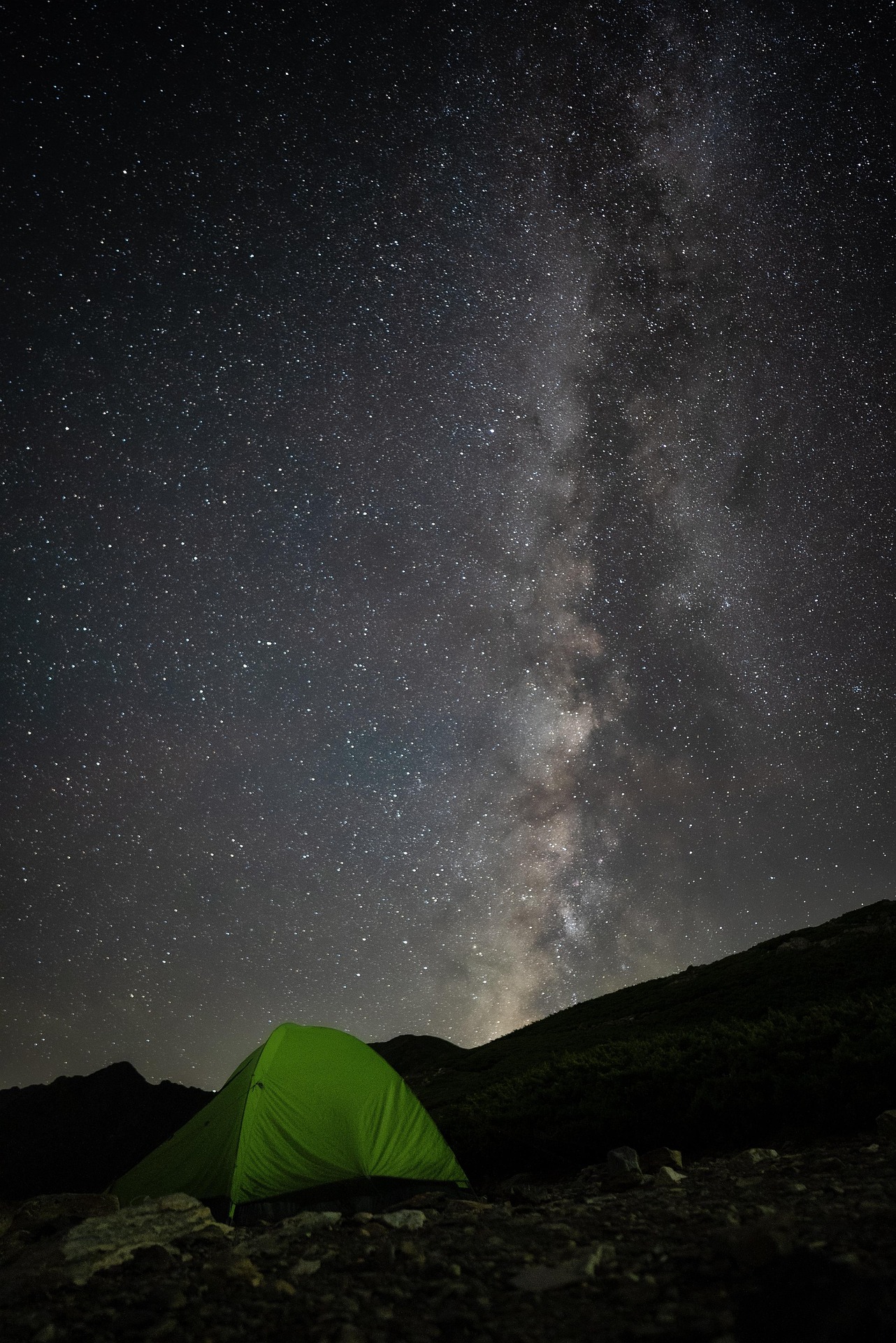 A green tent in the wilderness underneath the starry night, including the Milky Way
