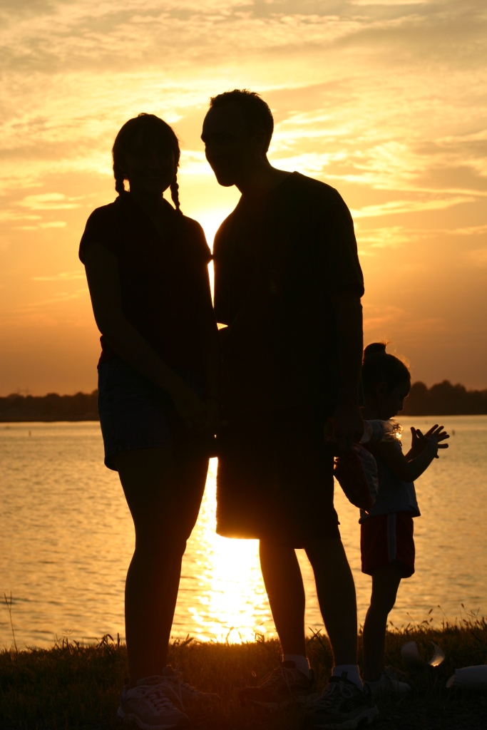 Family silhouetted by sun